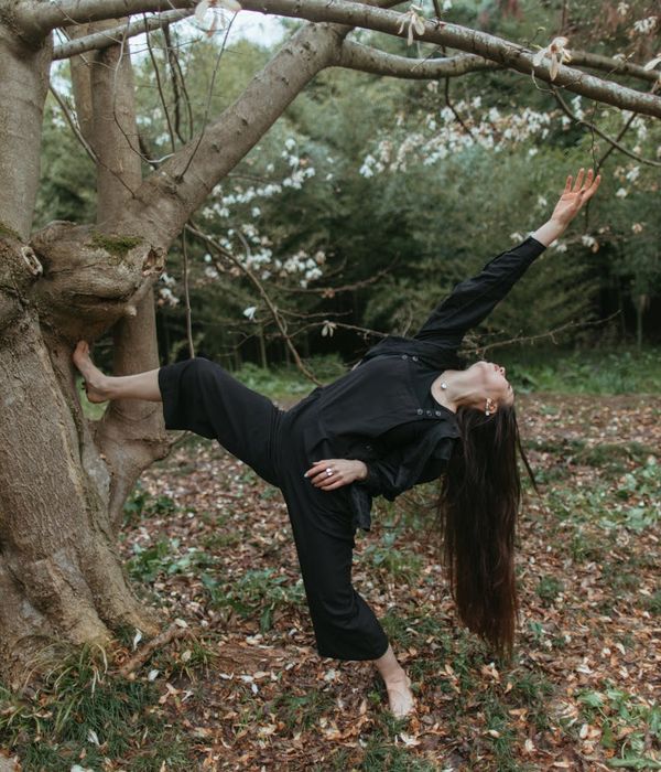 Woman performing a yoga balance pose in a calm environment.